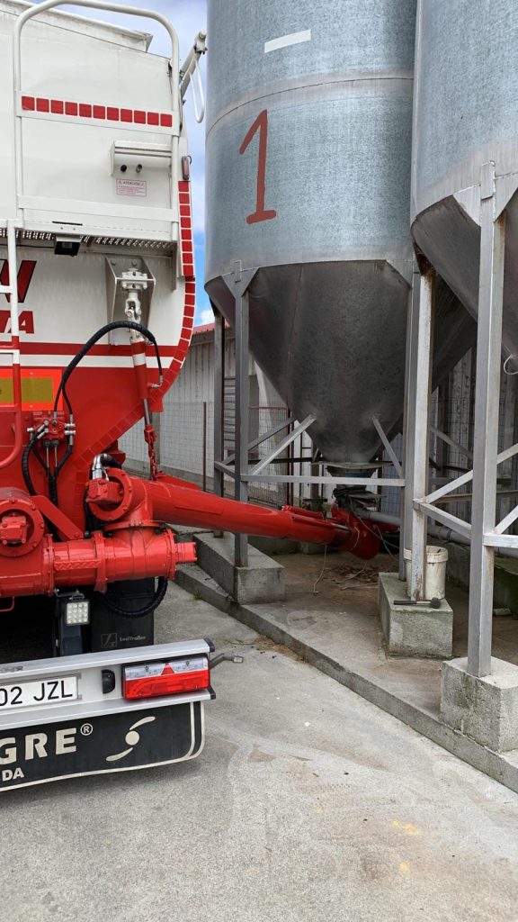 Camión cisterna Nanta en una planta de carga junto a grandes silos metálicos.