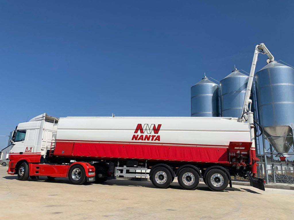 Camión cisterna Nanta en una planta de carga junto a grandes silos metálicos.